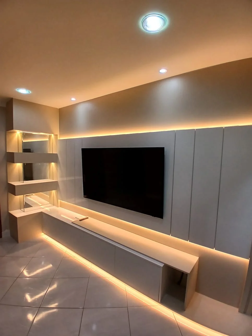 Painel de televisão cinza com iluminação indireta e detalhe ripado