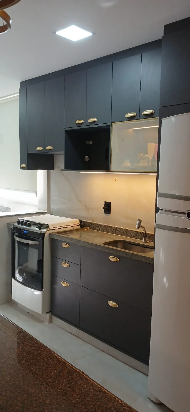 Cozinha branca compacta com bancada preta