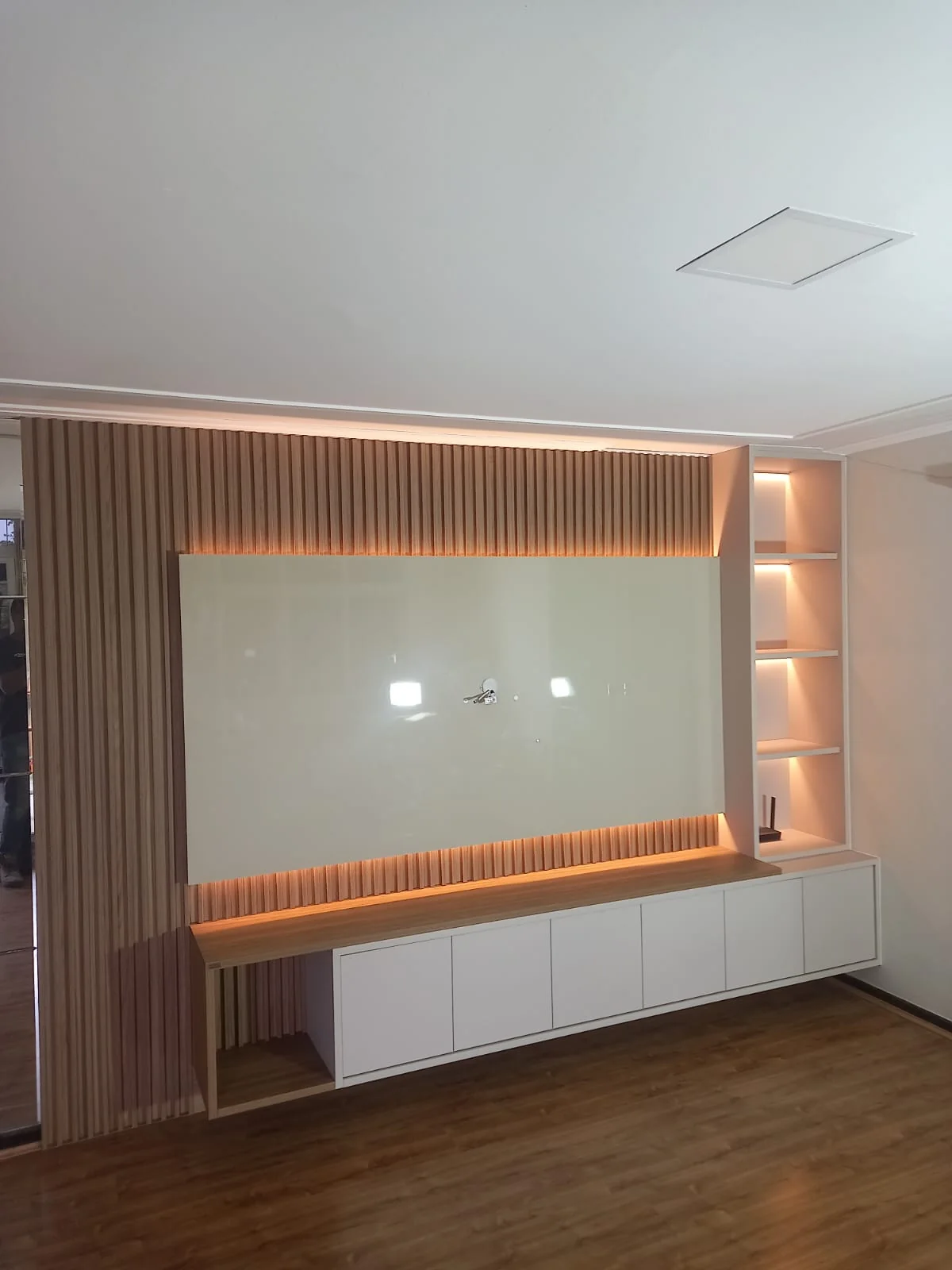 Painel planejado com madeira e iluminação